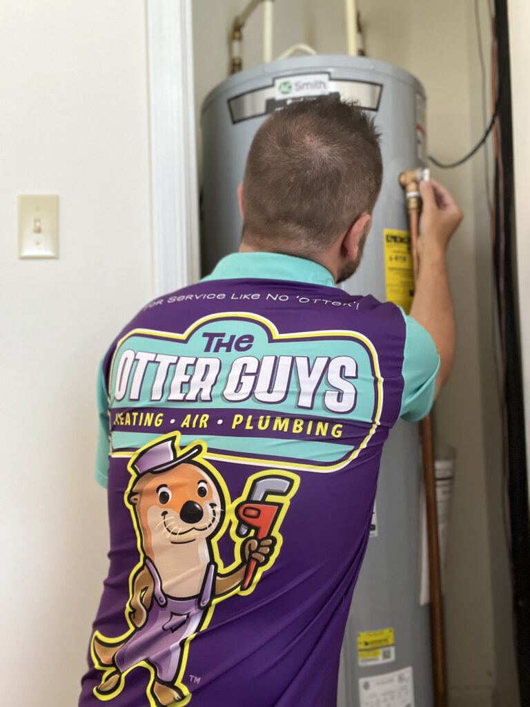A Plumber from The Otter Guys installing a Water Heater in Charlottesville, VA.