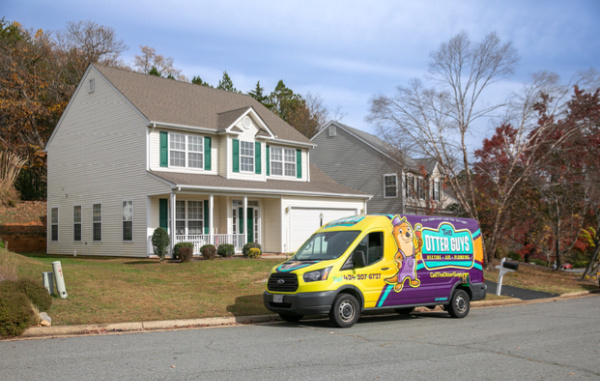 An Otter van parked in front of a two story house.