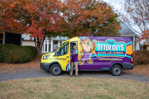 An Otter Guys employee standing in front the Otter van.