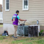 How to Prepare Your HVAC System for Spring Service tech washing an hvac system