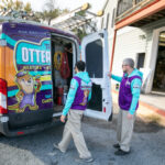 Two service men standing at the back of the service van.
