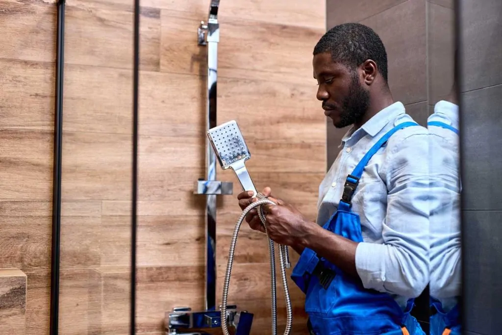 Otter employee installing a new shower head.