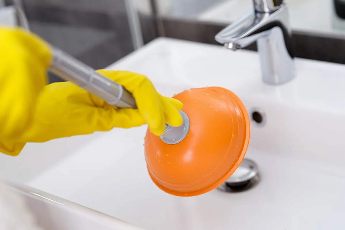 Why Is My Drain Slow or Clogged? Signs and Solutions unclogging a drain