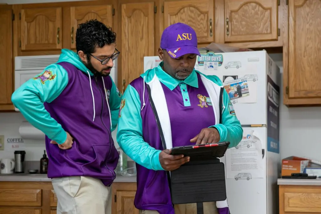 two otter employees reading the iPad