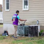 Homeowner Guide: How Do I Know If My HVAC System Needs Repair? An Otter Employee washing an HVAC system.